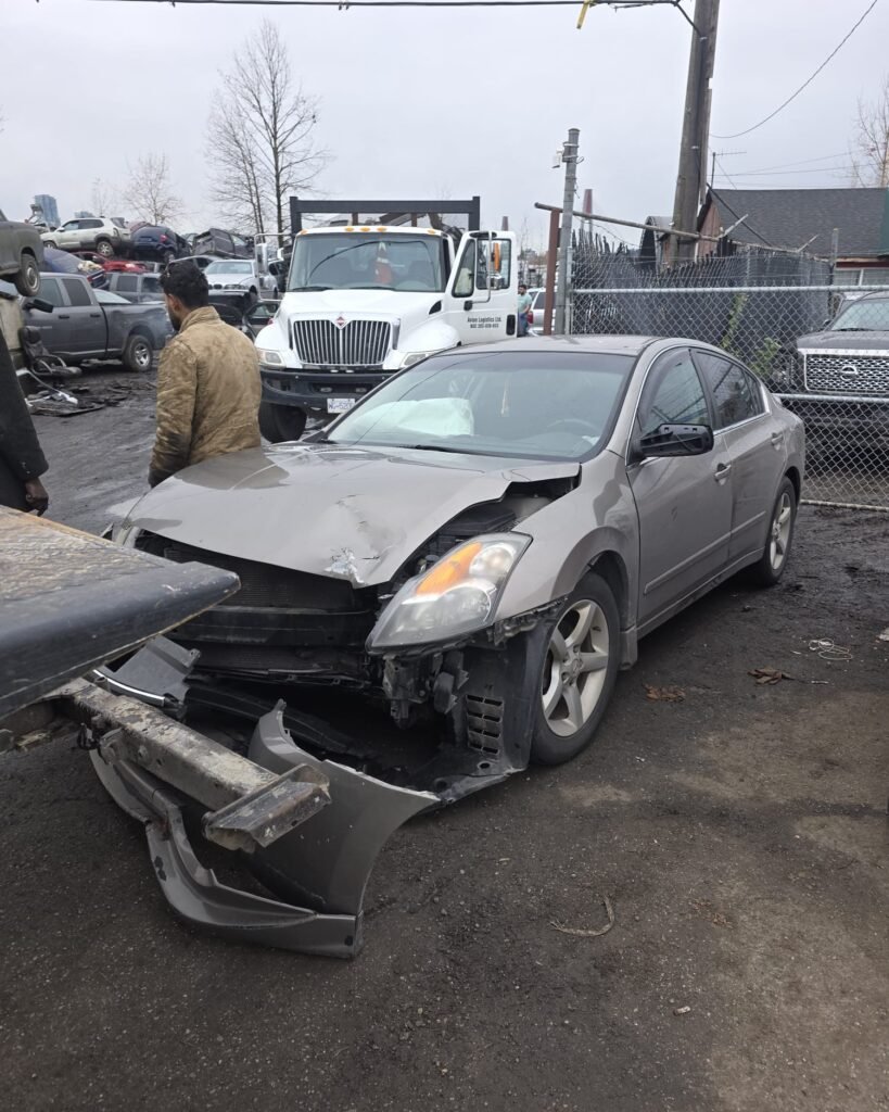Damaged grey sedan in a vehicle yard