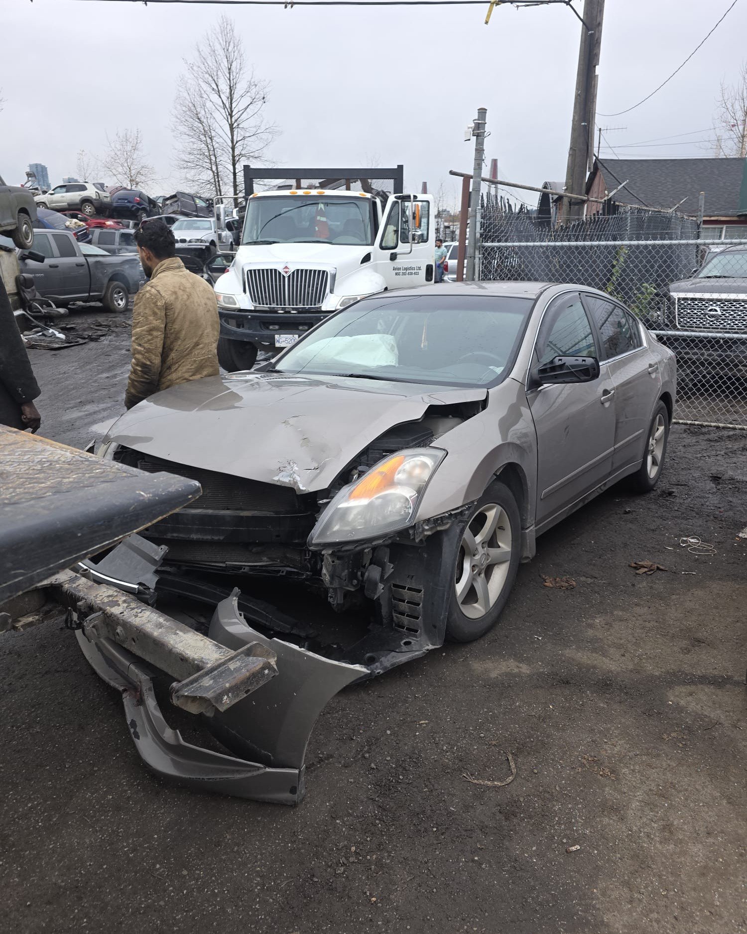 Damaged grey sedan in a vehicle yard
